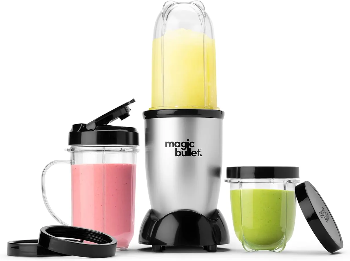 Magic Bullet 11-piece set laid out on a kitchen counter showing all cups, lids, and the motor base together