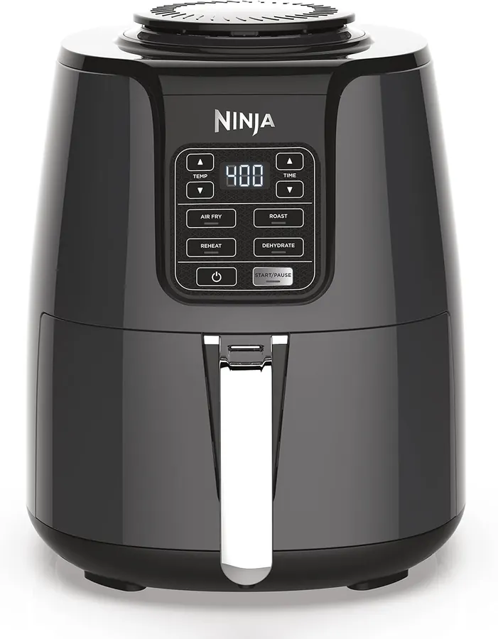 Person wiping down the Ninja AF101 basket with a sponge over a kitchen sink